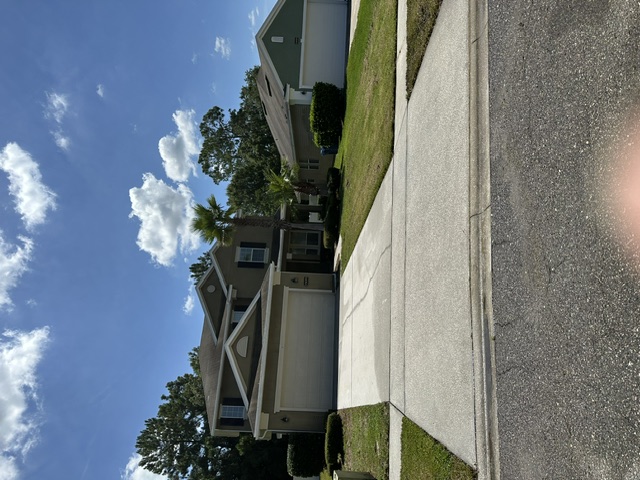 Two-story home with a clean driveway, apron and sidewalk from the street