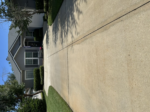 The same concrete driveway clean and uniform in color after pressure washing