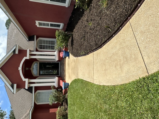 Curved front walkway cleaned to a light tan finish leading to a home entry